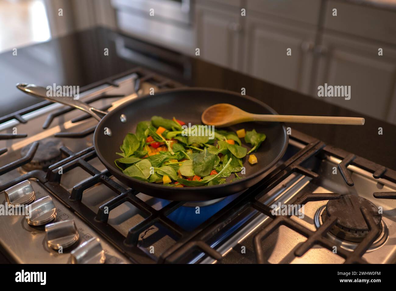 Mescolare le verdure fritte in una padella sul piano cottura Foto Stock