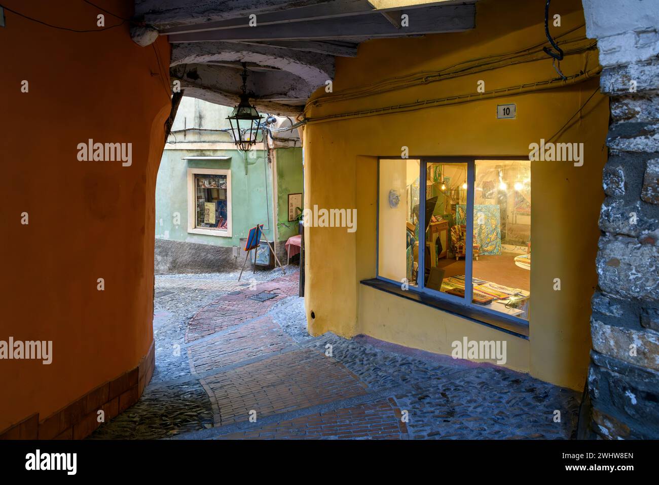 Un piccolo negozio illuminato a la Pigna di Sanremo, il centro storico medievale della città costiera di Sanremo, in Italia. Foto Stock