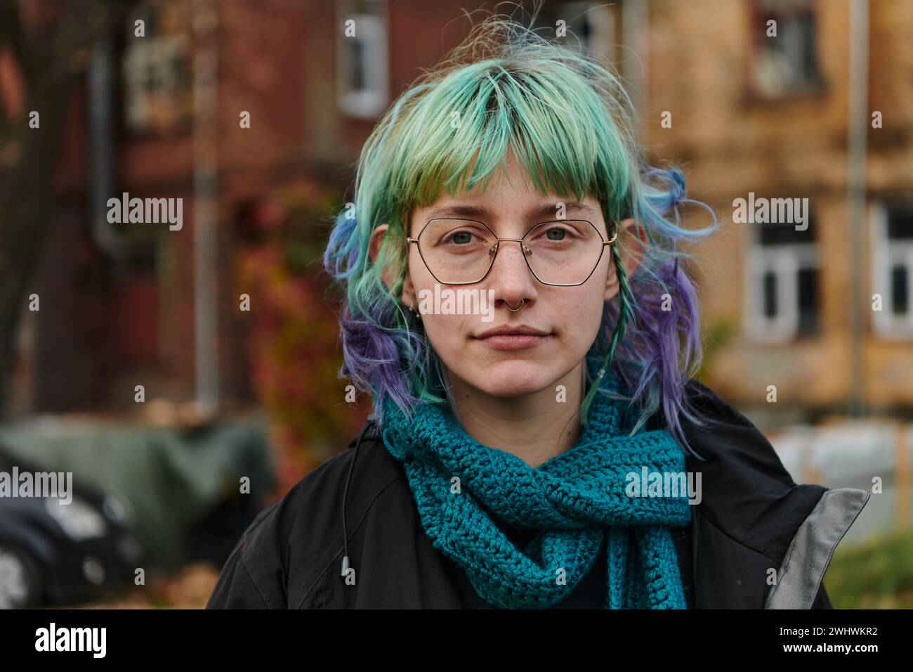 Un ritratto accattivante di una giovane e interessante ragazza dai capelli azzurri, scattata nel parco di fronte alla sua casa, che mostra Foto Stock