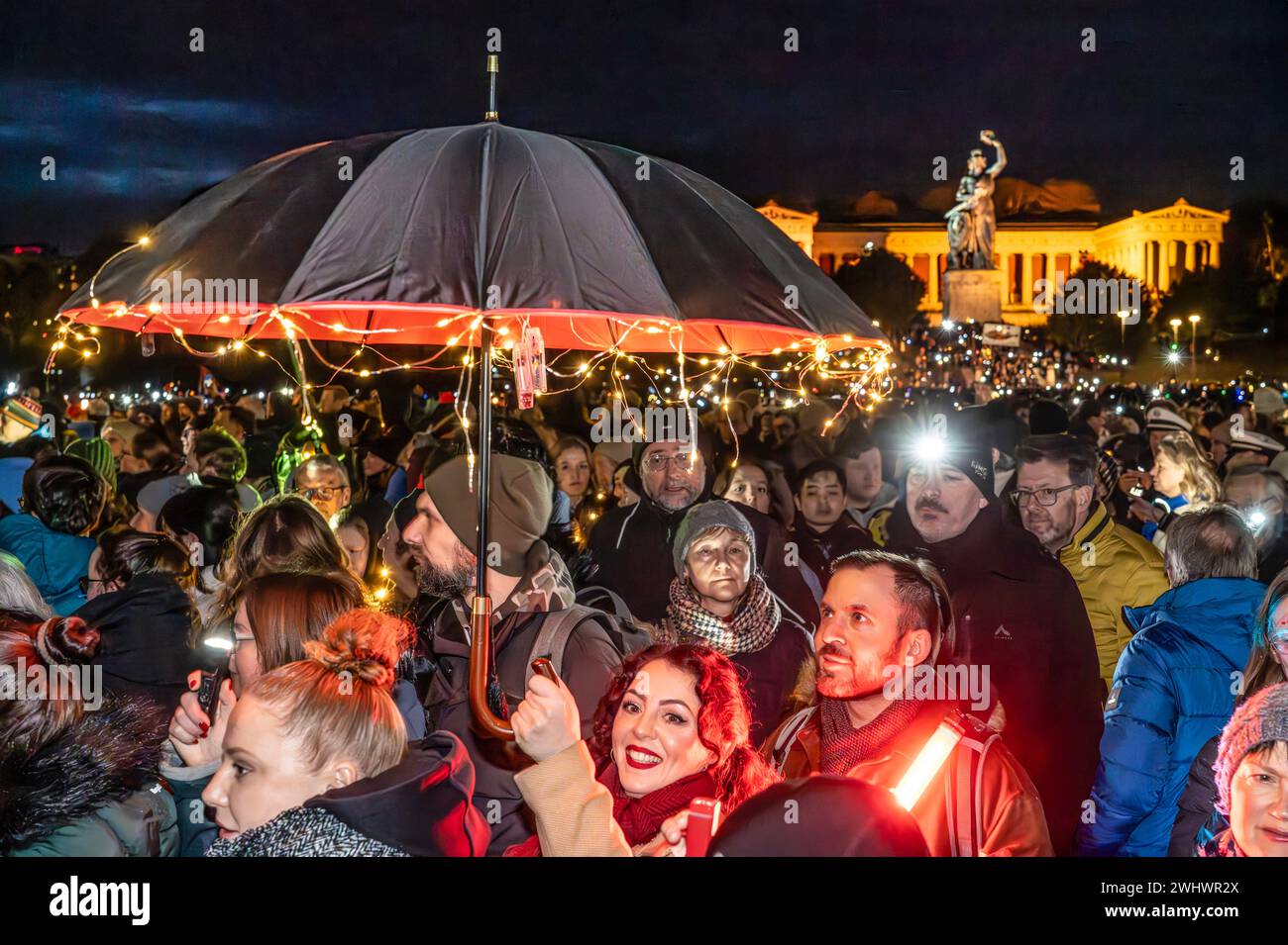 Lichtermeer für Demokratie, Kundgebung gegen Rassismus, Antisemitismus und Hetze, Theresienwiese, München, 11. febbraio 2024 Deutschland, München, 11. Febbraio 2024, Teilnehmerin mit beleuchtetem Regenschirm, Lichtermeer für Demokratie, Kundgebung gegen Rassismus, Antisemitismus und Hetze, ca. 100,000 Teilnehmer mit Lichtern auf der Theresienwiese, ab 18 Uhr, Veranstalter Fridays for Future und ein breites Aktionsbündnis zivilgesellschaftlicher Initiativen und Organisationen, dabei Lichterkette e.V., Bellevue di Monaco, München ist bunt und vielen mehr, *** Sea of Lights for Democracy, rally aga Foto Stock