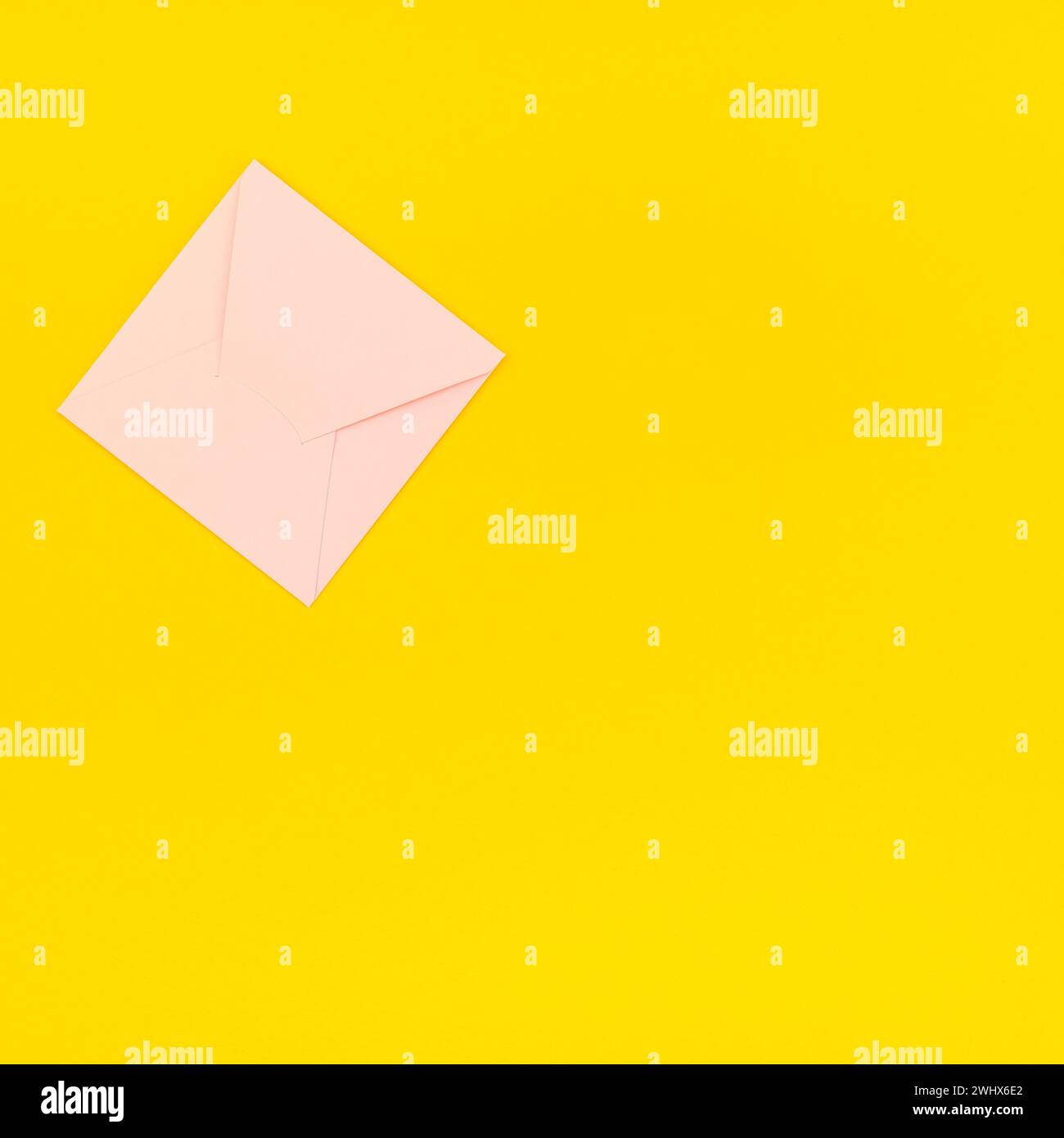 Busta rosa pastello su sfondo giallo Foto Stock