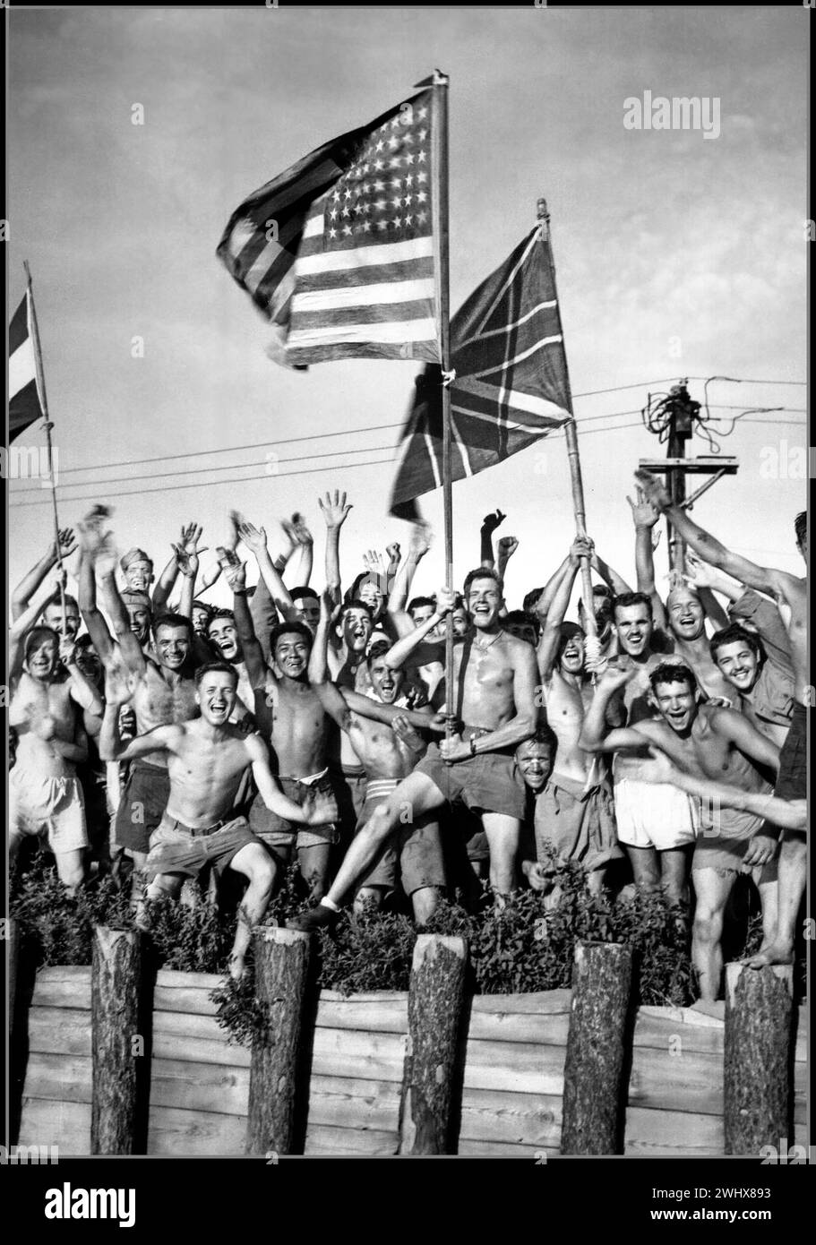 Prigionieri di guerra giapponesi della seconda guerra mondiale Gaunt alleati prigionieri di guerra nel campo di Aomori vicino a Yokohama tifo soccorritori della Marina degli Stati Uniti. Sventolando le bandiere degli Stati Uniti, della Gran Bretagna e dell'Olanda. Giappone, 29 agosto 1945. (Navy) Foto Stock