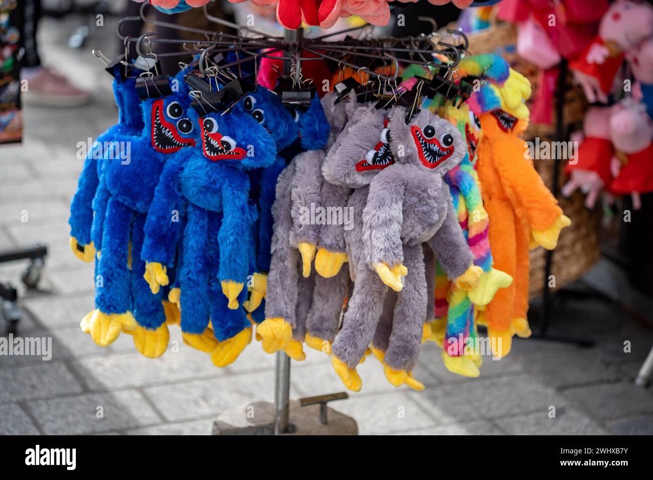 Un mucchio di giocattoli Huggy Wuggy della serie di giochi Poppy Playtime in vendita durante un mercato festivo locale. Giocattoli di gioco popolari, coniuga un concetto semplice Foto Stock