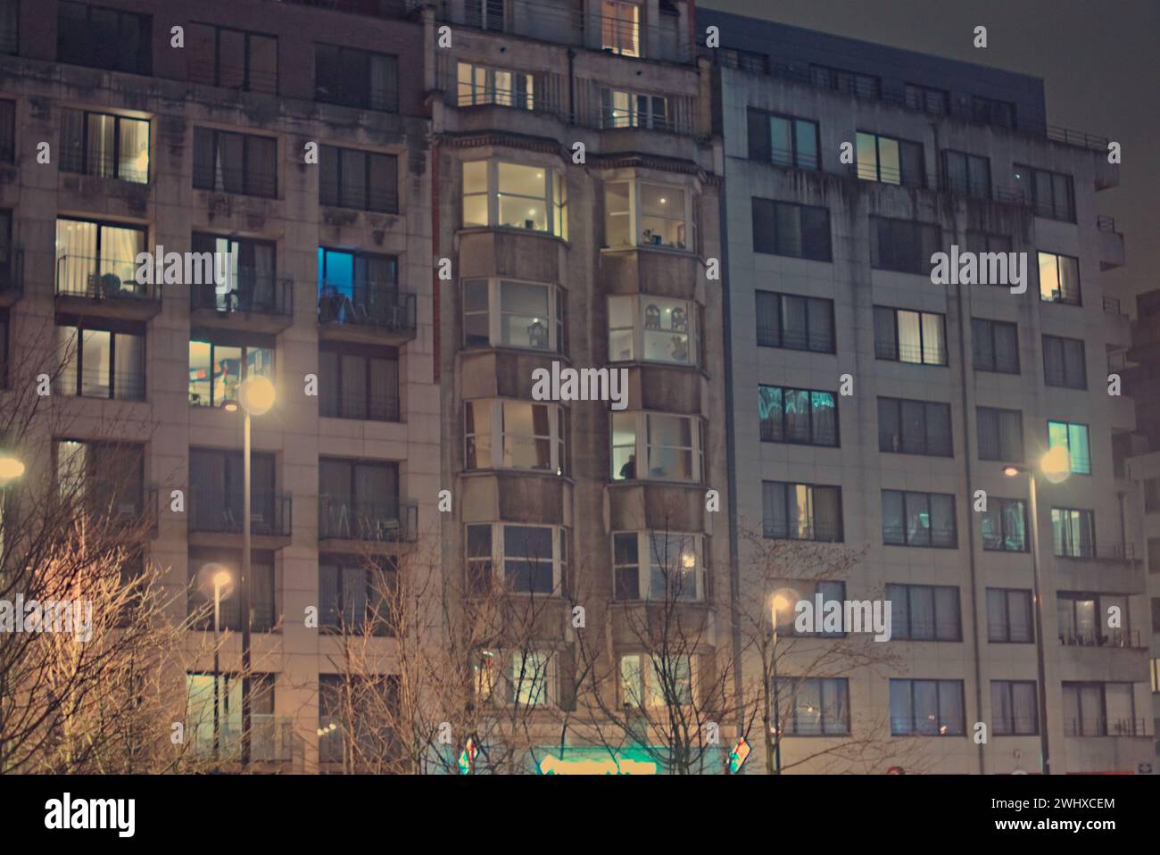 Bruxelles, Belgio. 5 febbraio 2024. Facciata di edifici a Bruxelles. Fotografia di strada. Edificio ad appartamenti a piu' piani con luci accese Foto Stock