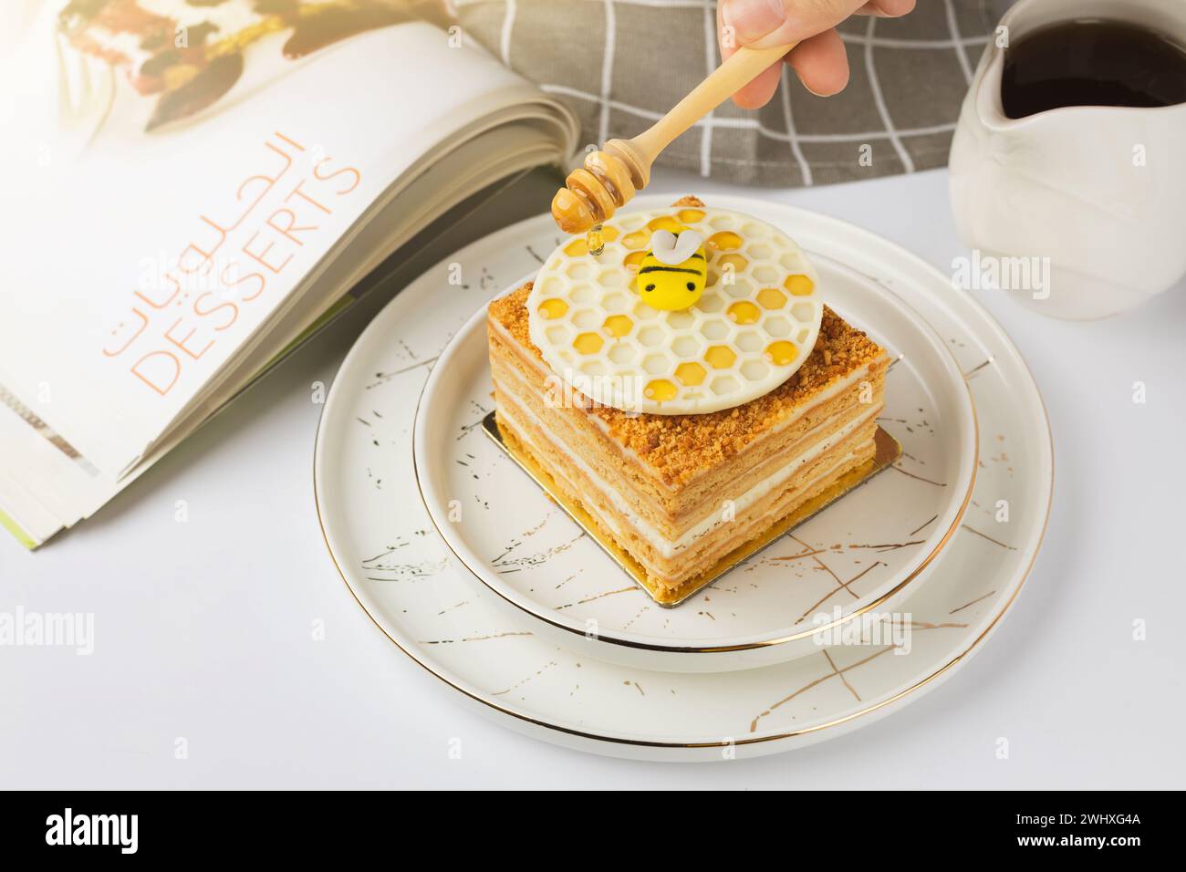 Torta Napoleone con miele su sfondo bianco Foto Stock