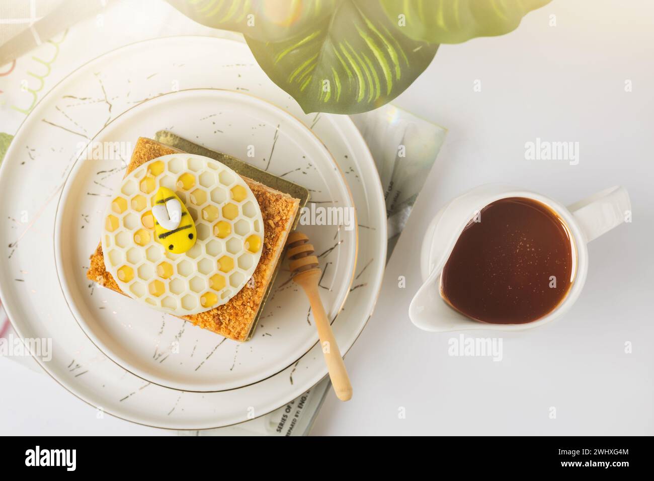 Torta Napoleone con miele su sfondo bianco Foto Stock