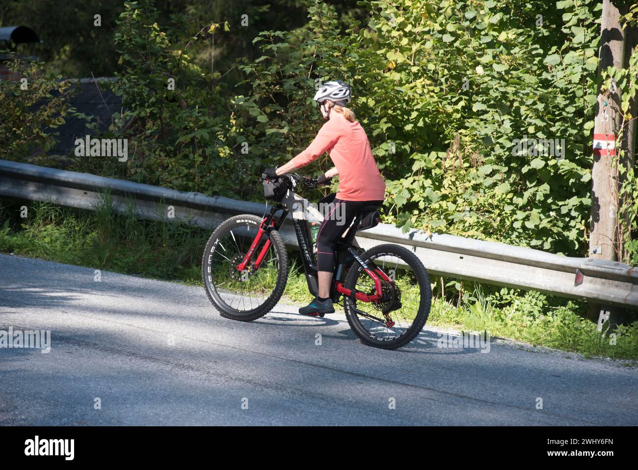 Guida e trasporto su una bicicletta elettrica Foto Stock