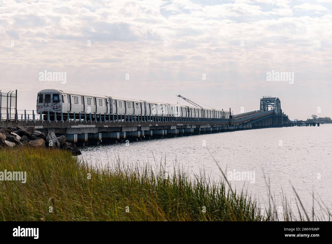 Vista di Un treno che attraversa il ponte sulla Jamaica Bay nel Queens, New York. Metropolitana a New York, fuori dall'hotel Foto Stock