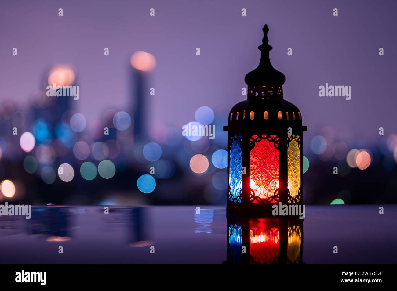Lanterna con cielo notturno e città bokeh sfondo luminoso per la festa musulmana del mese santo di Ramadan Kareem. Foto Stock