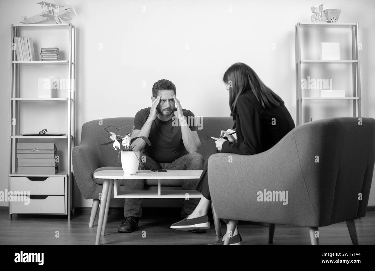 L'uomo che dice allo psicologo circa i problemi di dipendenza di abuso. Terapia depressa per problemi nell'uomo di mezza età. Foto Stock