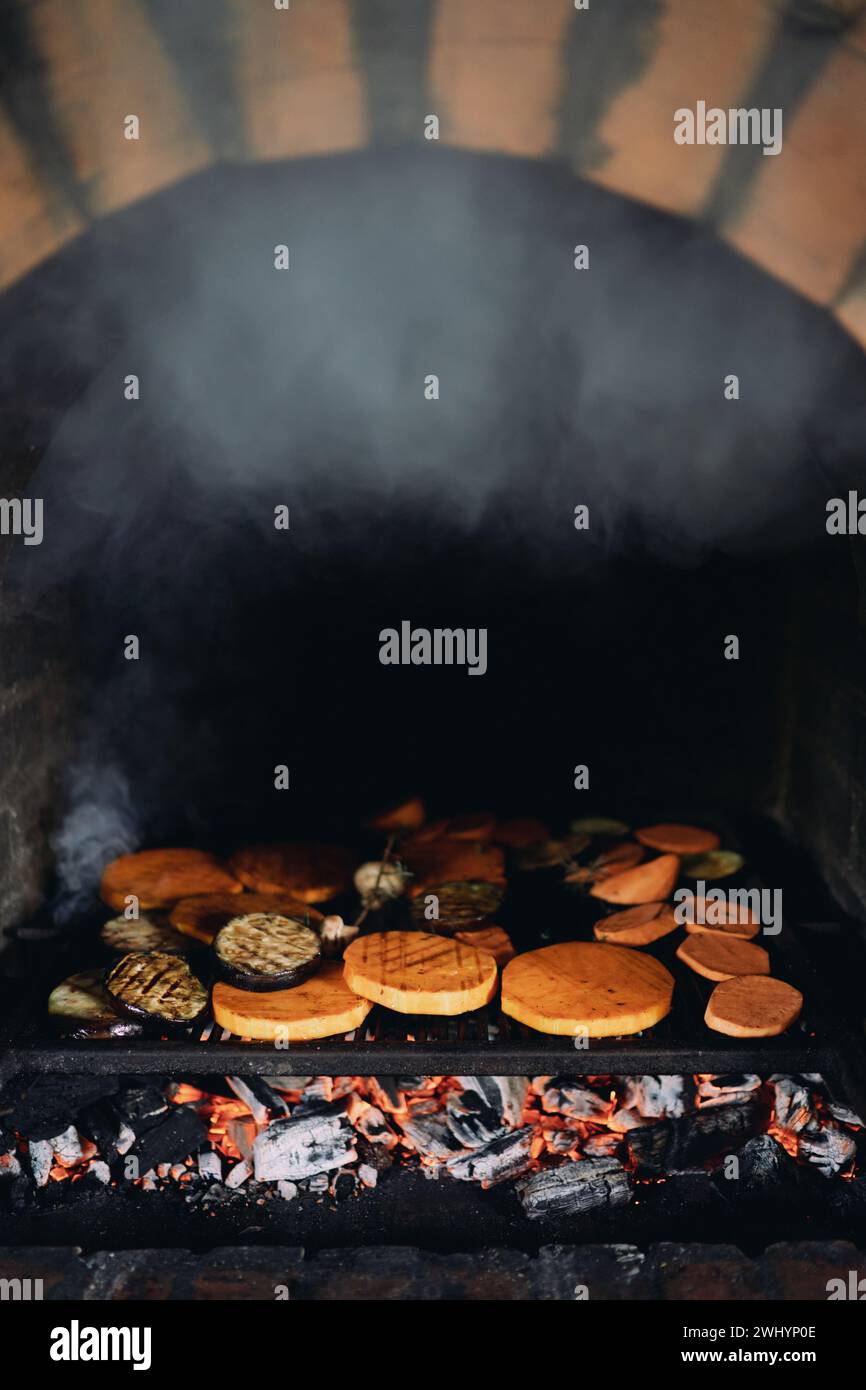 Le verdure fresche a fette vengono cotte su una griglia in un forno a mattoni Foto Stock