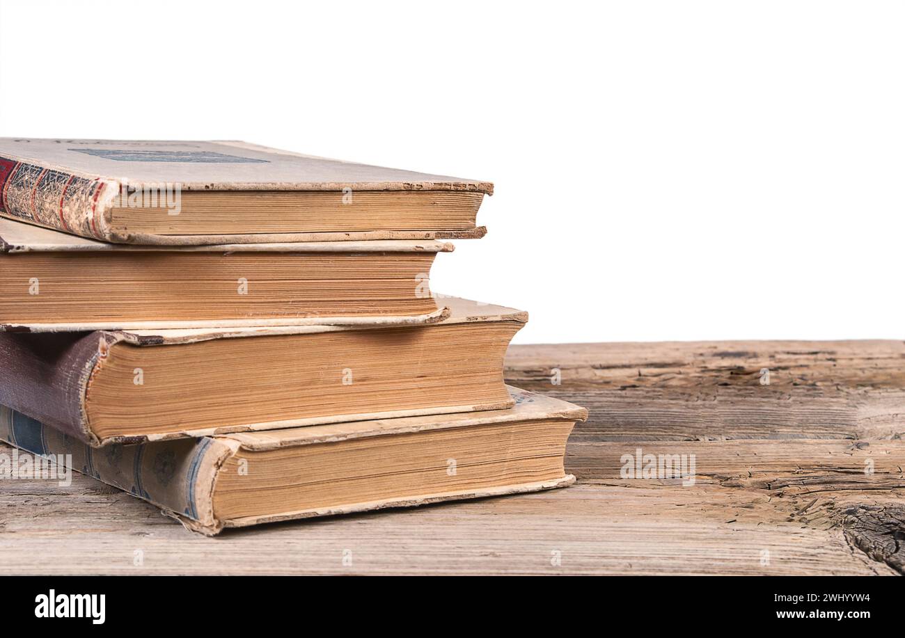 Vecchi libri su una superficie in legno testurizzato isolata su sfondo bianco Foto Stock