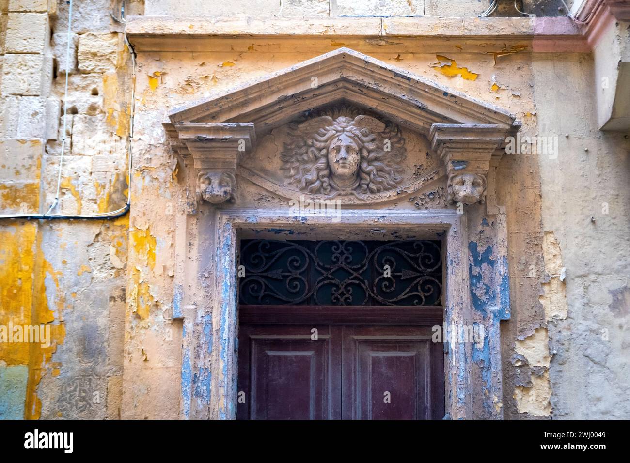 Vernice sbiadita e sbiadita su una porta a la Valletta, Malta Foto Stock