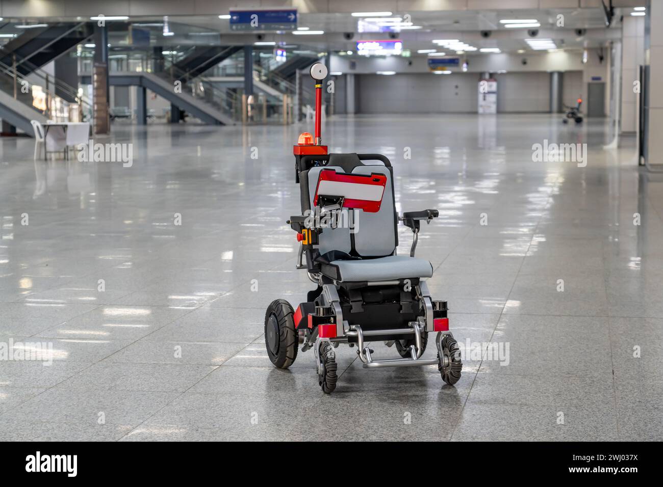 Moderna sedia a rotelle tecnologica con telecomando, robot con intelligenza artificiale, per il trasporto di passeggeri in aeroporto o in stazione Foto Stock