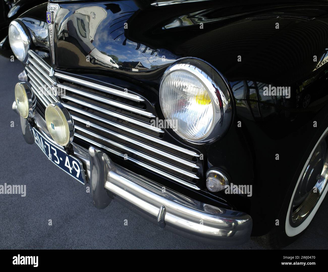 Itterbeck, Germania - 1 novembre 2022 i fari, la griglia e il paraurti di una vecchia Peugeot nera 203 C. l'auto è del 1955 Foto Stock