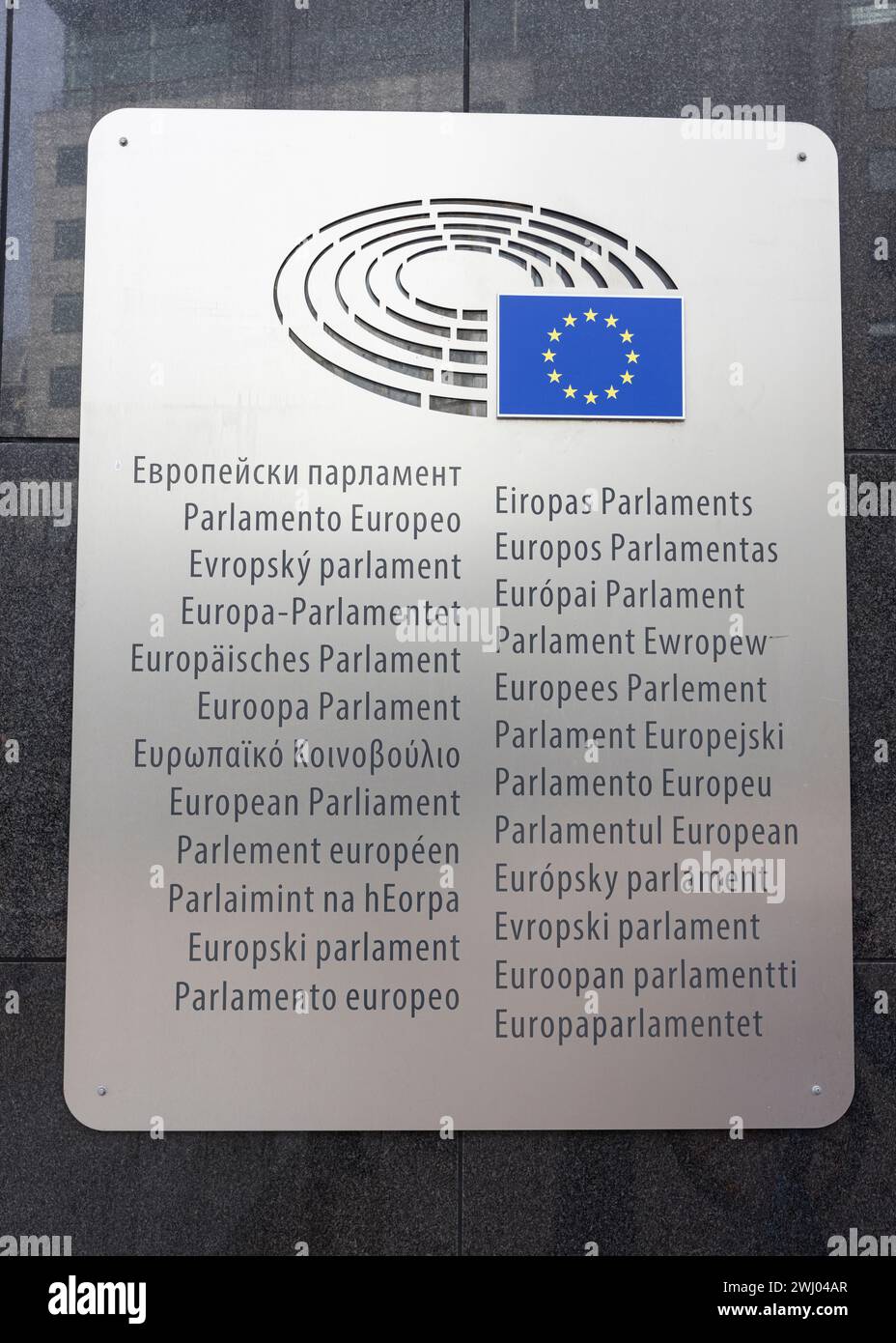 La targa con la bandiera e il logo dell'Unione europea sul muro del Parlamento europeo, con il suo nome nella lingua di ogni Stato membro Foto Stock