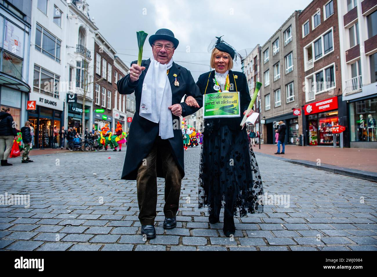 Nijmegen, Paesi Bassi. 11 febbraio 2024. Una coppia si vede sfilare mentre indossa costumi tradizionali. A Nimega, nei Paesi Bassi, la sfilata di carnevale consiste in un galleggiante trainato da un veicolo elettrico pieno di principi e principesse dell'anno. Il resto della sfilata è composto da persone vestite con costumi colorati e bande musicali. L'attrazione principale ogni anno è il costume che il sindaco della città Huber Bruls indosserà, quest'anno il tema era Flower Power. Credito: SOPA Images Limited/Alamy Live News Foto Stock