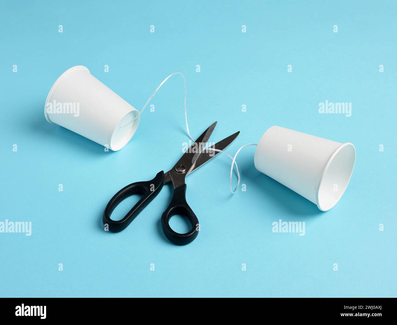 Errore di comunicazione. Divieto o errore di comunicazione. Errore di connessione. Censura. Telefono con tazza di carta e forbici per tagliare la corda di connessione. Foto Stock