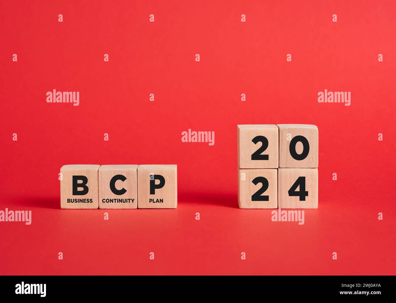 L'abbreviazione BCP business continuity plan per l'anno 2024 su cubi di legno con sfondo rosso. Foto Stock