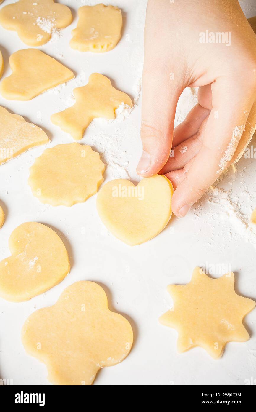La ragazza mostra la forma del cuore con l'impasto Foto Stock