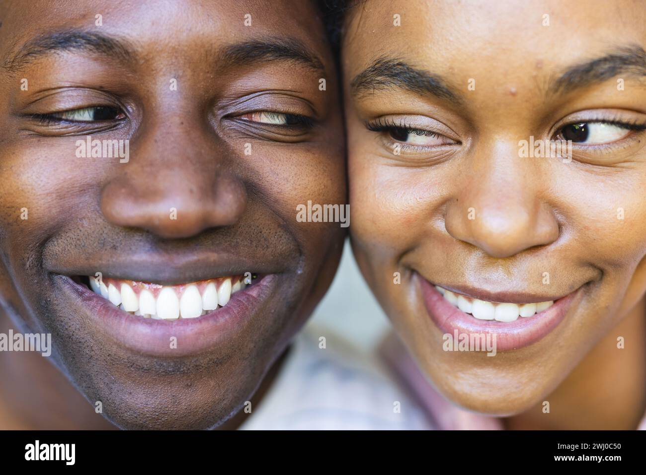 Una giovane coppia ama utilizzare un'app per la casa intelligente, sorridendo insieme. Foto Stock