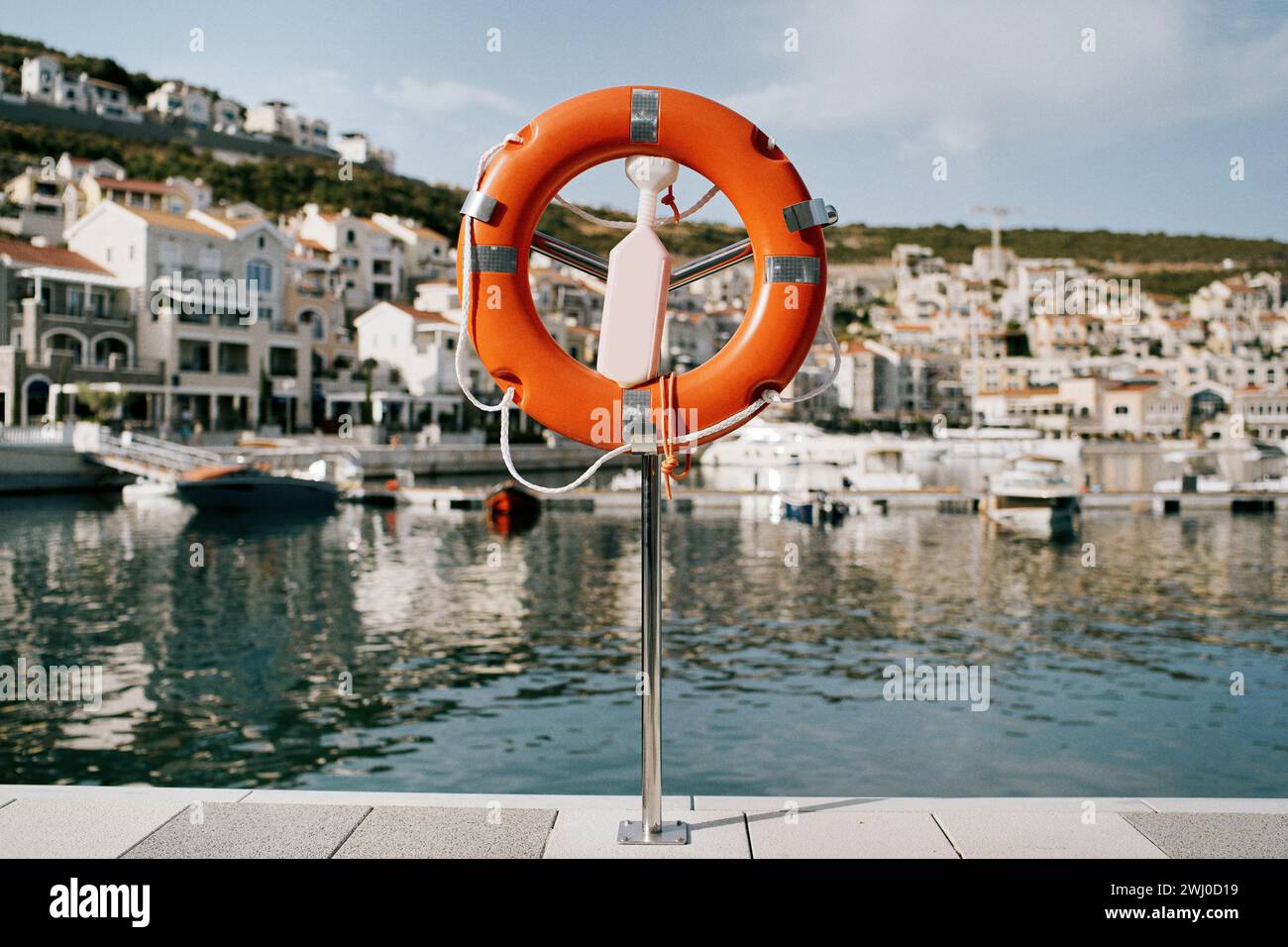 Lifebuoy su un piedistallo con chiavistello si trova su un molo di Lustica Bay. Montenegro Foto Stock