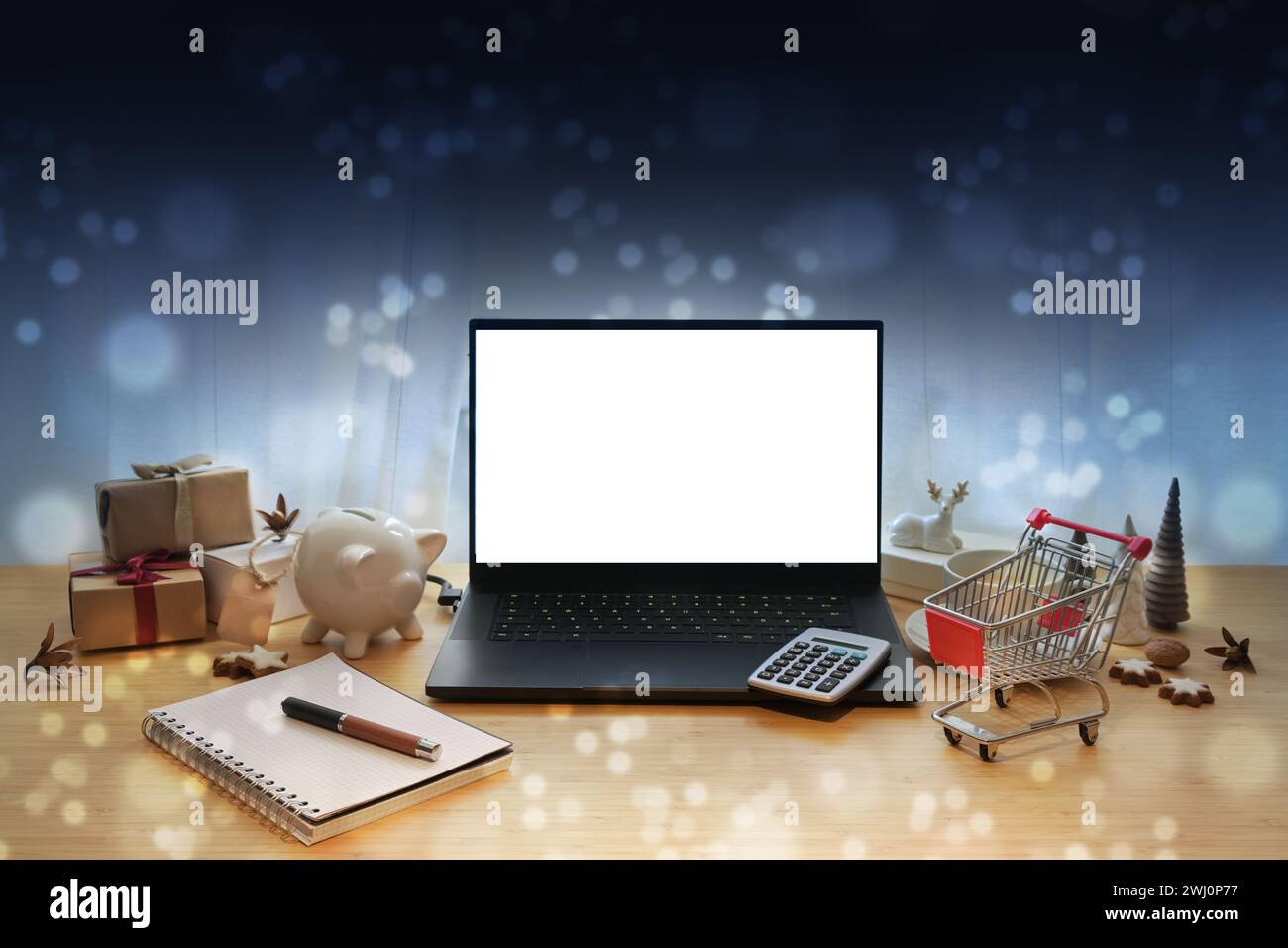 Mockup per laptop, offerte di vendita online come il Black Friday, tavolo con decorazioni natalizie, regali, calcolatrice, carrello della spesa, maialino Foto Stock