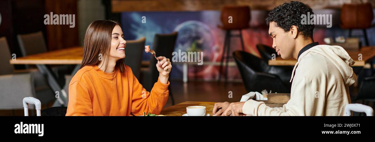 coppie diverse che condividono un momento di gioia con un pasto sano in un caffè alla moda, banner Foto Stock