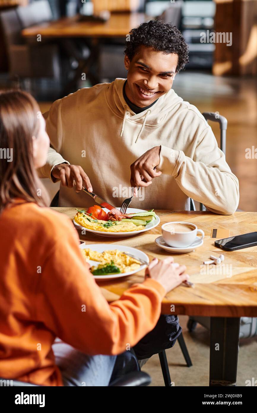 la coppia felice condivide un momento tranquillo insieme, mentre si godono un pranzo caldo nel comfort di un accogliente caffè Foto Stock