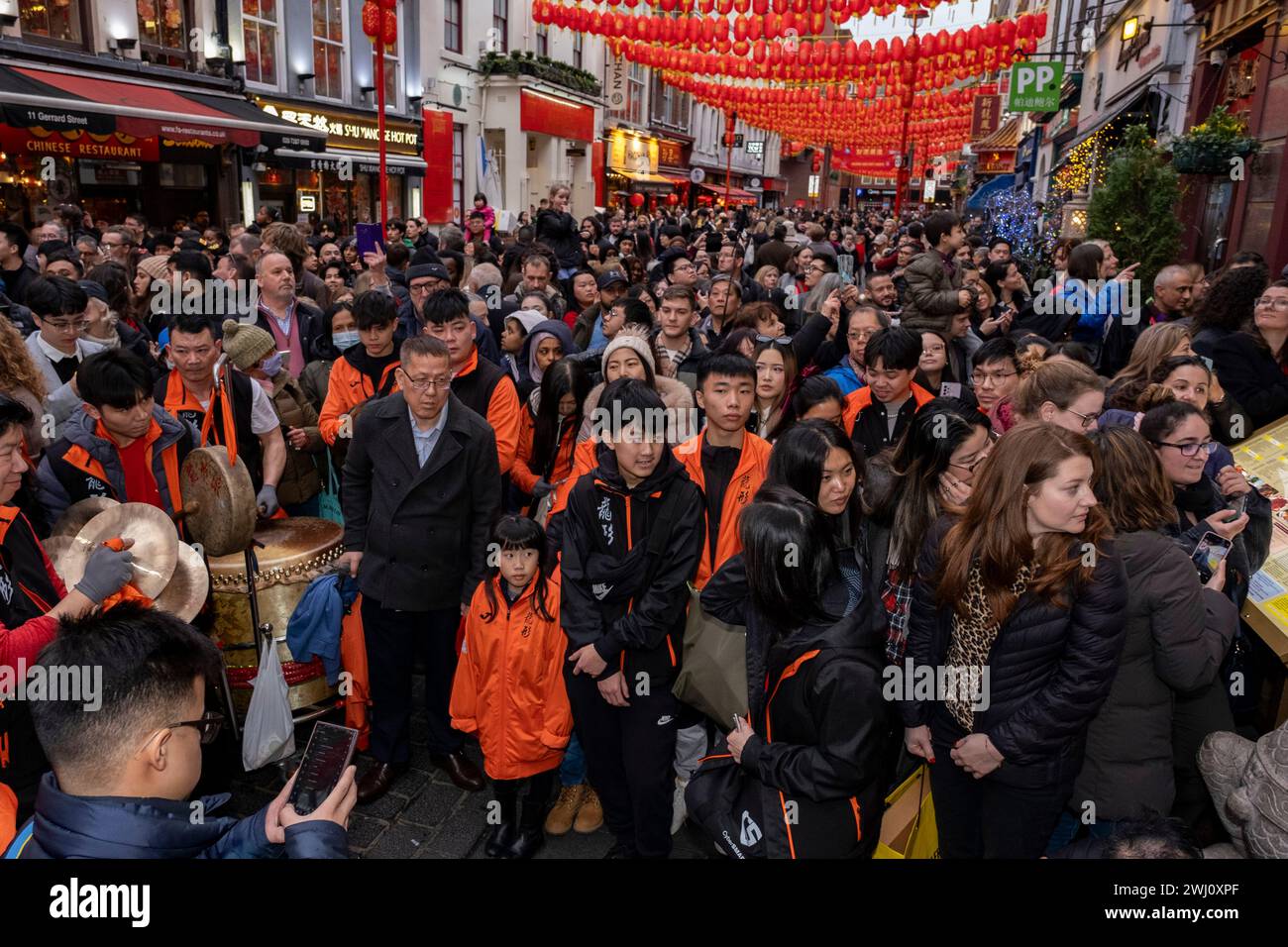 La folla si riunisce per assistere a una danza del leone per celebrare il capodanno cinese del drago che entra nei ristoranti di Chinatown per benedirli per l'anno che precede il 10 febbraio 2024 a Londra, Regno Unito. Chinatown è un'enclave etnica confinante con Soho e attualmente occupa l'area intorno a Gerrard Street. Contiene un certo numero di ristoranti cinesi, panetterie, supermercati, negozi di souvenir e altre aziende a gestione cinese. Foto Stock