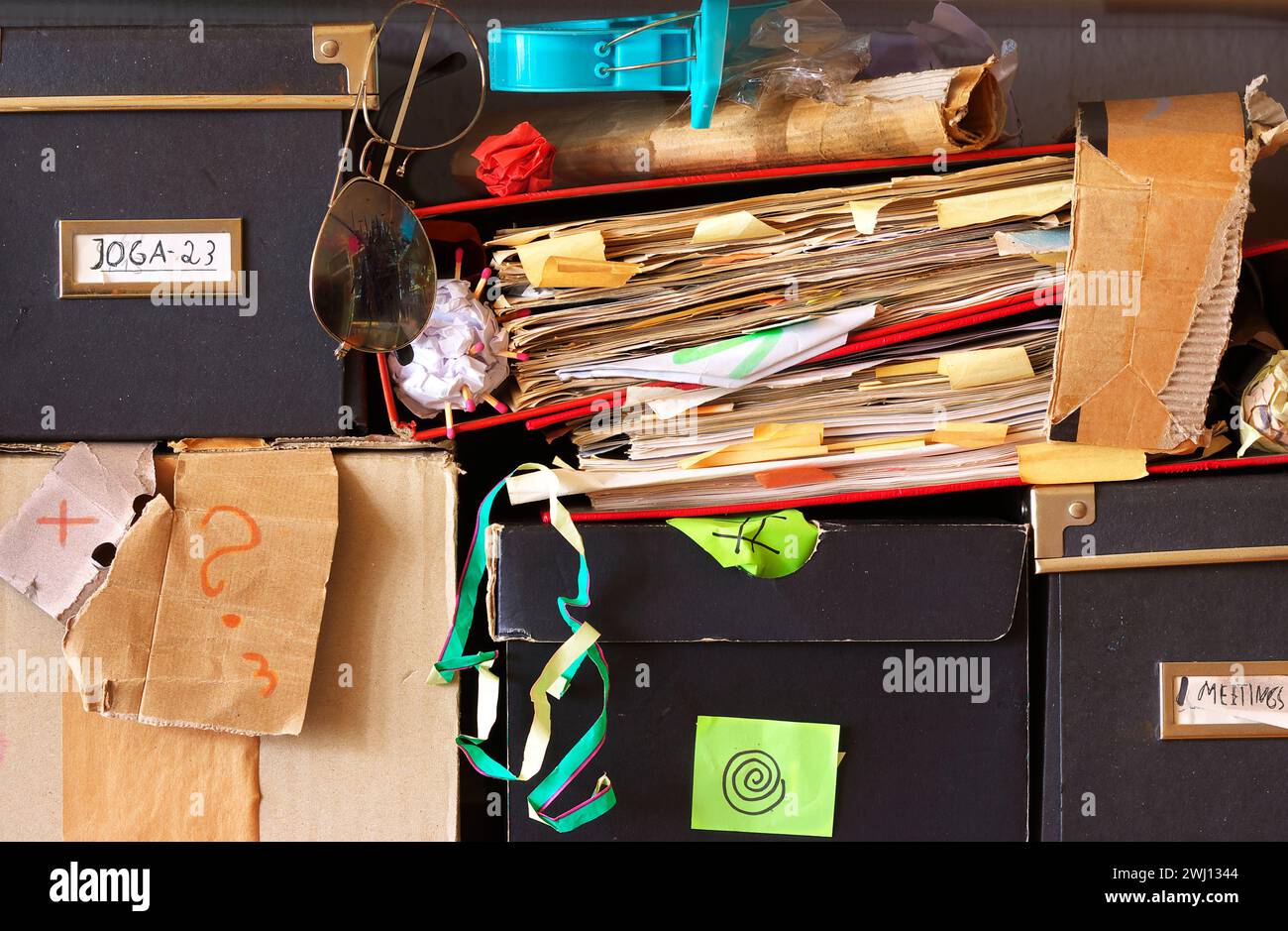 cartelle di file e contenitori disordinati in una libreria per ufficio ingombrante, burocrazia, aminificazione, concetto aziendale, spazio di copia gratuito. Foto Stock