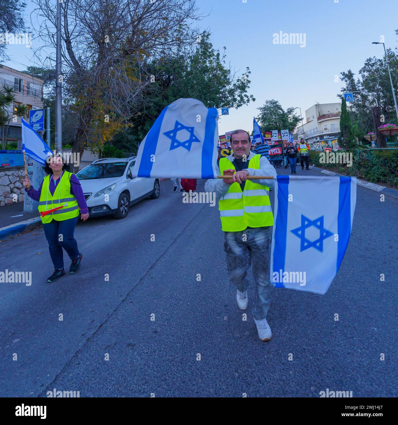 Haifa, Israele - 10 febbraio 2024: La gente marcia con vari segni e bandiere per protestare contro il governo, chiedendo nuove elezioni. Haifa, Isra Foto Stock