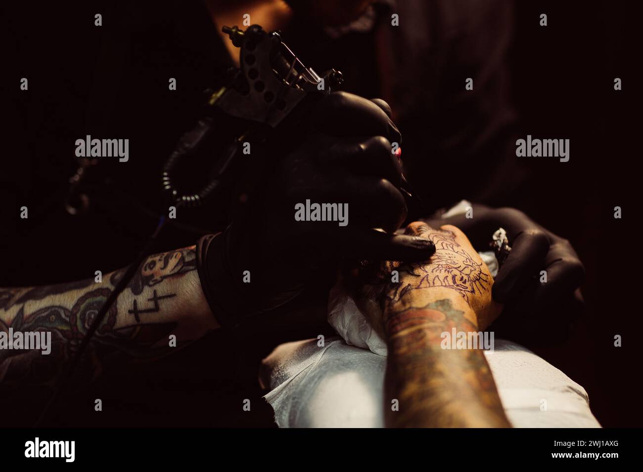 Tatuatore al lavoro su un design a maniche colorate. Foto Stock