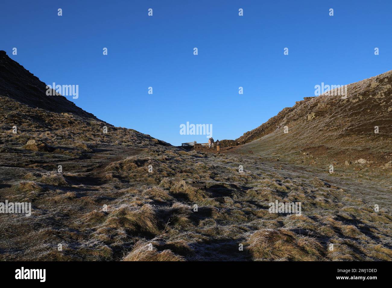 I turisti posano per delle foto al Sycamore Gap sul Vallo di Adriano, dove un tempo cresceva l'iconico albero di sicomoro. L'albero fu abbattuto dai vandali nel dicembre 2023 Foto Stock