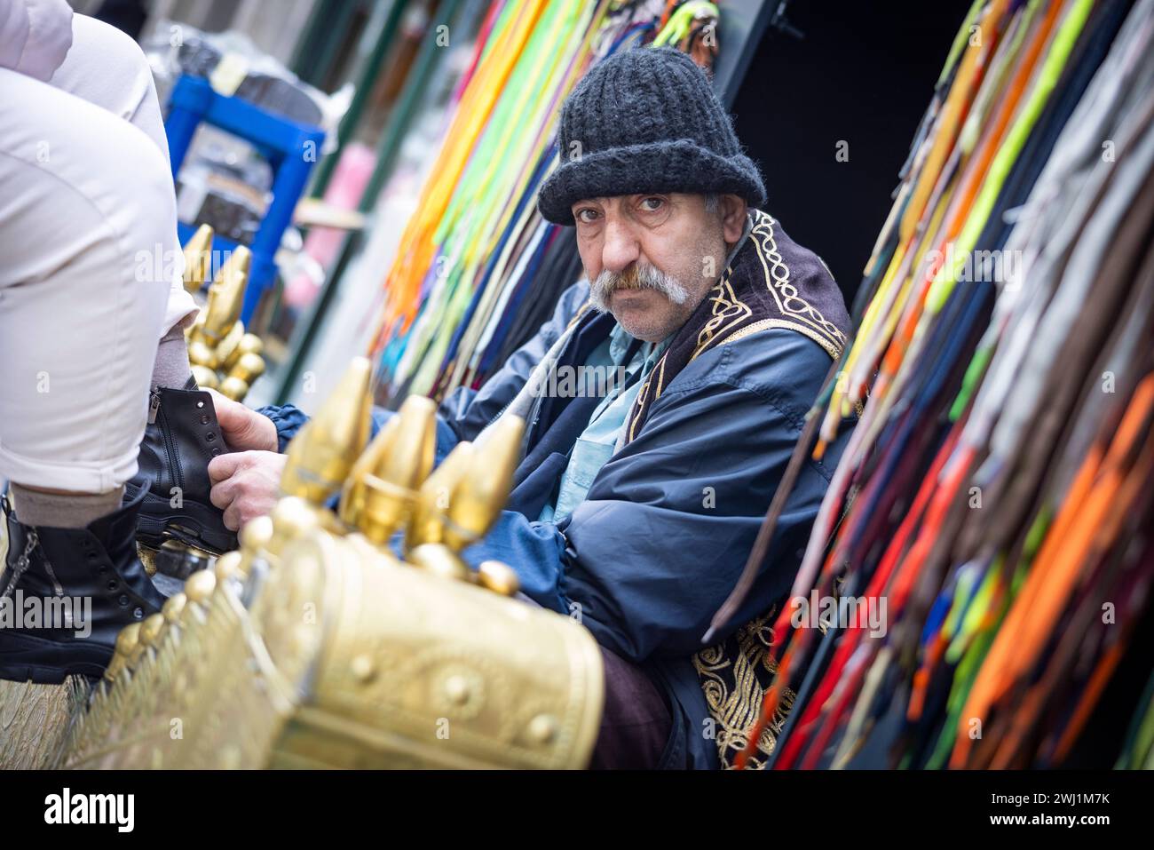 Istanbul 11022024 - Ein Schuhputzer vor bunten Schnuersenkeln in der Innenstadt von Istanbul, unweit vom Taksim-Platz. Istanbul Taksim Istanbul Turkiye *** Istanbul 11022024 Un ragazzo lustrascarpe di fronte ai colorati lacci delle scarpe nel centro di Istanbul, non lontano da Piazza Taksim Istanbul Taksim Istanbul Turkiye 110224 ppb-2 Foto Stock