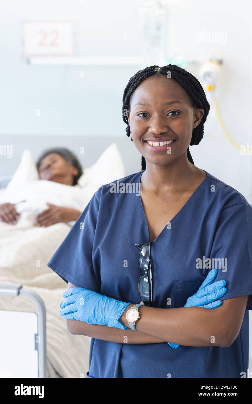 Ritratto di felice medico africano americano che indossa guanti protettivi nella stanza d'ospedale Foto Stock