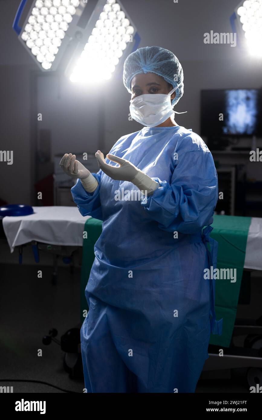 Ritratto di medico donna afroamericana con maschera e guanti in sala operatoria dell'ospedale Foto Stock