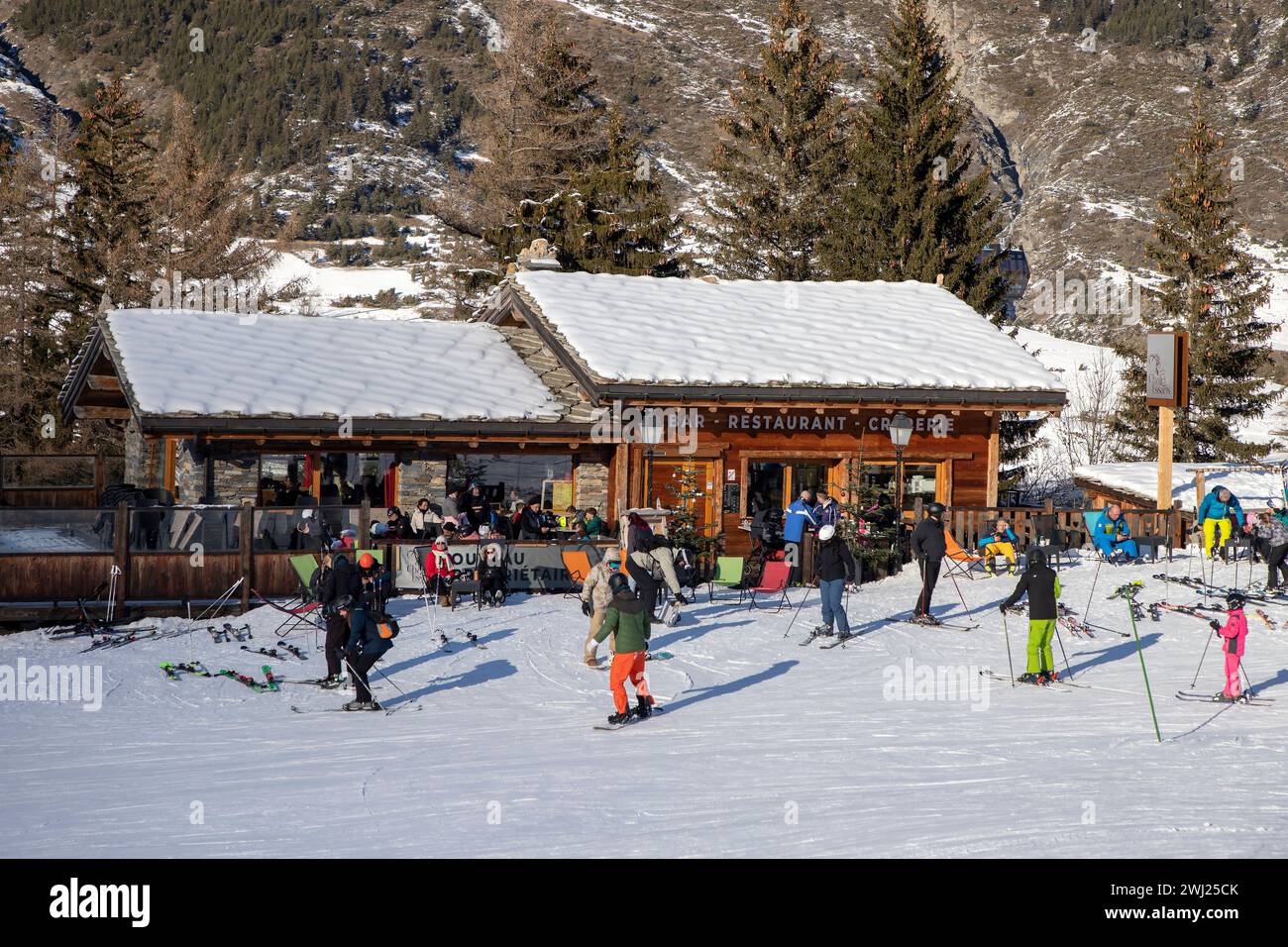 Sciatori intorno al ristorante situato ai piedi della pista da sci in Val-Cenis, Francia Foto Stock