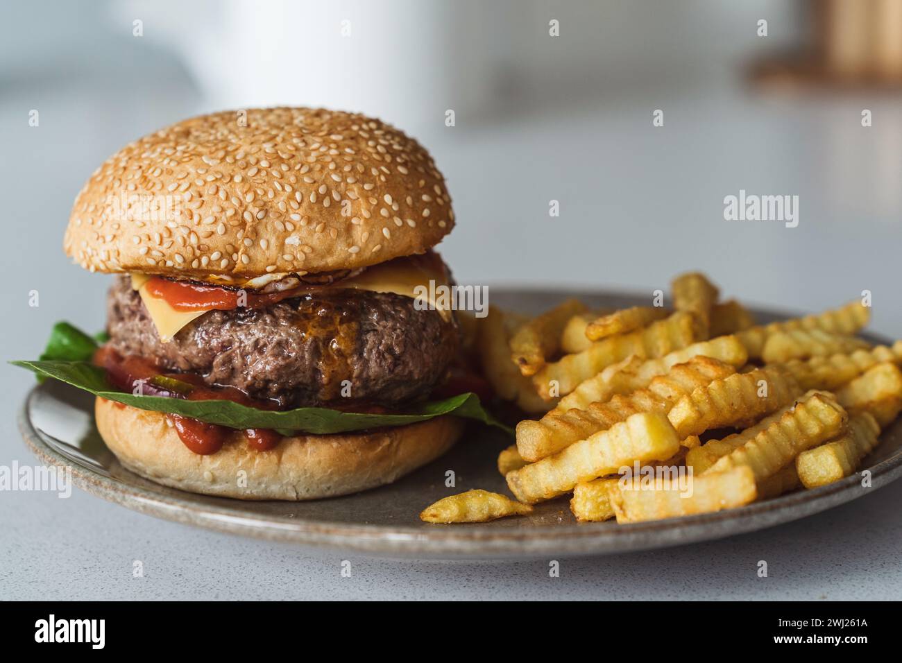 Deliziosi cheeseburger fatti in casa su un piatto accompagnato da patatine fritte dorate e croccanti Foto Stock