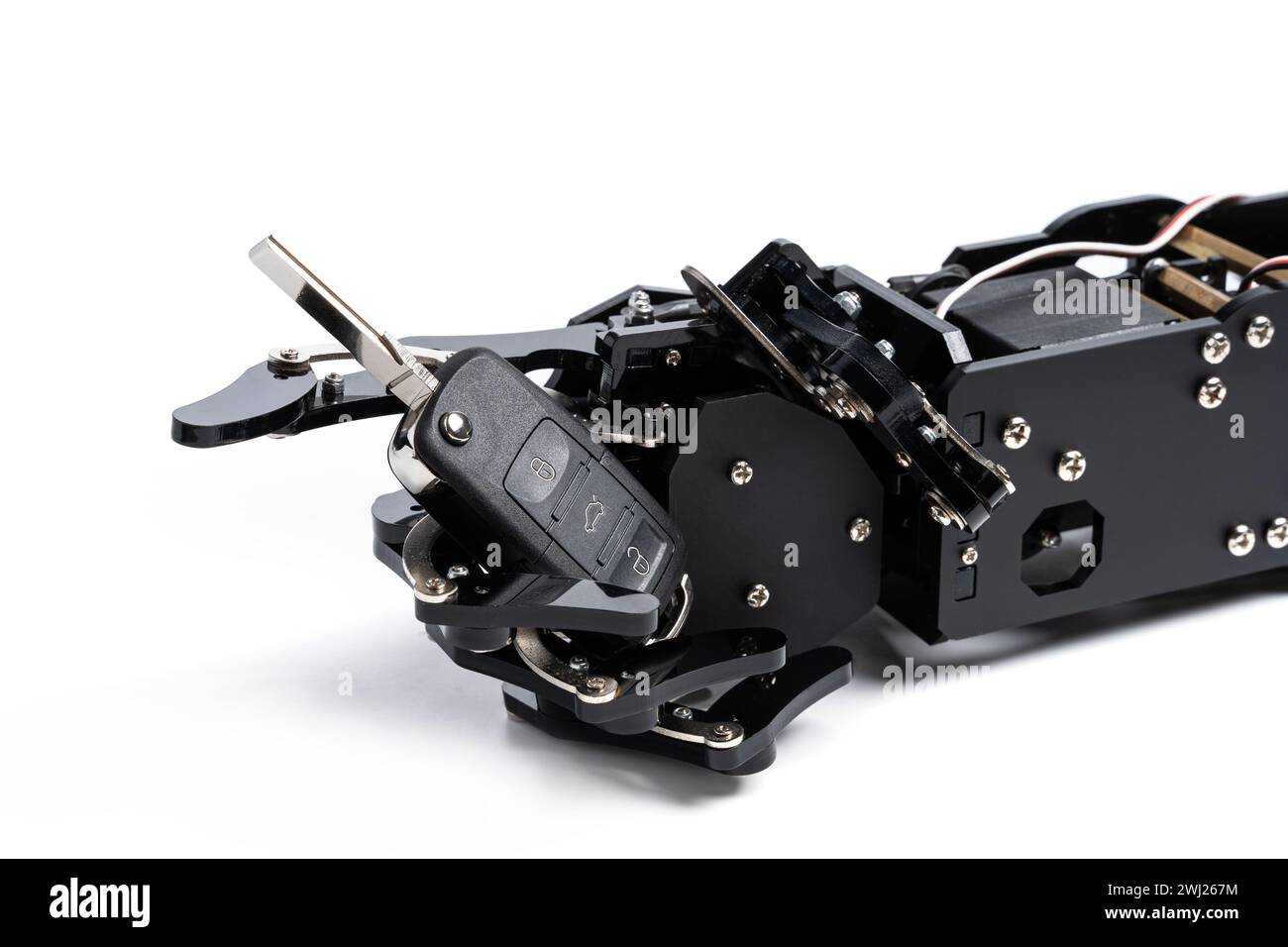 Una vera mano robotica con la chiave dell'auto nera. Concetto di intelligenza artificiale nel settore dei trasporti Foto Stock