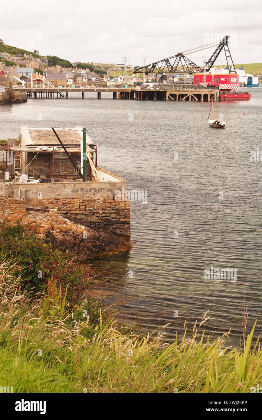 Il porto di Stromness, guardando da sud a nord, mostra il retro delle proprietà sul lungomare e la trafficata scena portuale Foto Stock