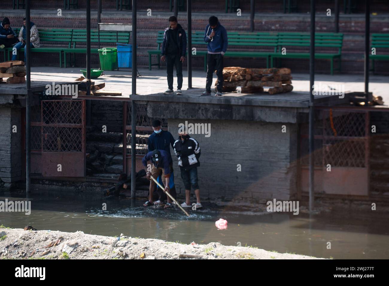 Raccolta di avanzi di legno al tempio di Pashupatinath sulla riva del sacro crematorio del fiume Bagmati, Kathmandu, Nepal, lunedì 12 febbraio 2024 Foto Stock