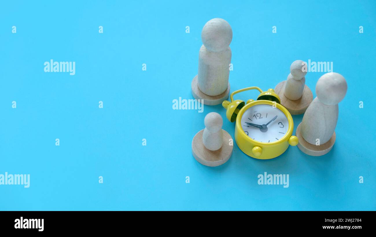 Tempo di qualità trascorso con la famiglia. Sveglia con persone in legno che rappresentano un genitore e un bambino. Foto Stock