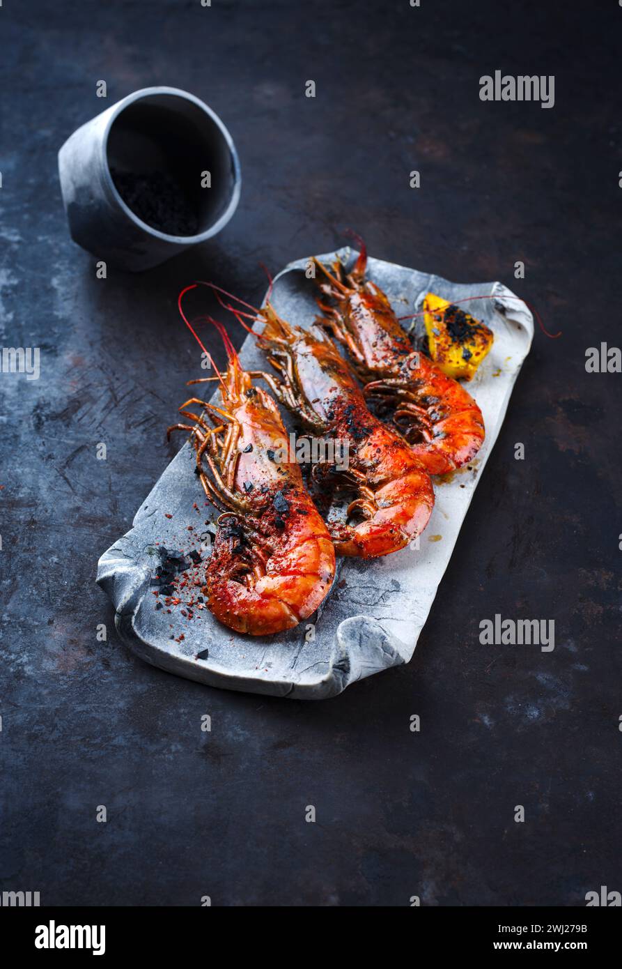 I tradizionali gamberoni fritti con pezzi di ananas e sale nero sono serviti da primo piano su un vassoio di design con spazio per testo Foto Stock