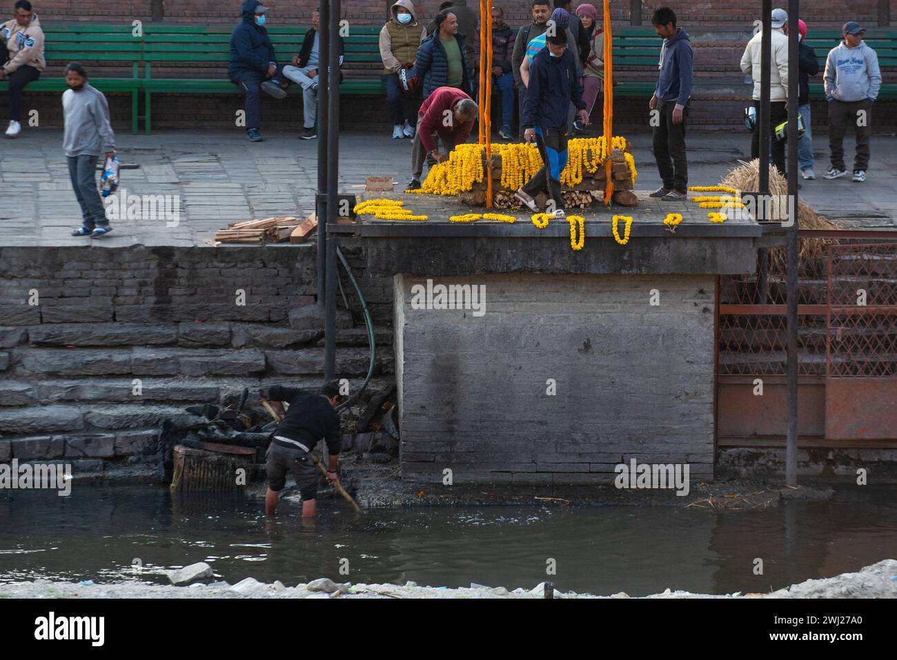 Raccolta di avanzi di legno al tempio di Pashupatinath sulla riva del sacro crematorio del fiume Bagmati, Kathmandu, Nepal, lunedì 12 febbraio 2024 Foto Stock