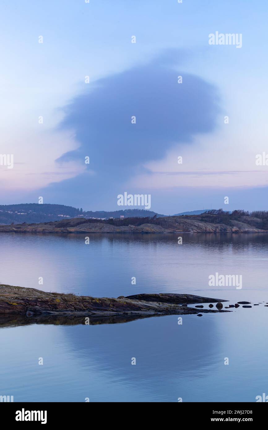 Cielo mattutino con nuvole magenta sul paesaggio costiero roccioso in Svezia Foto Stock