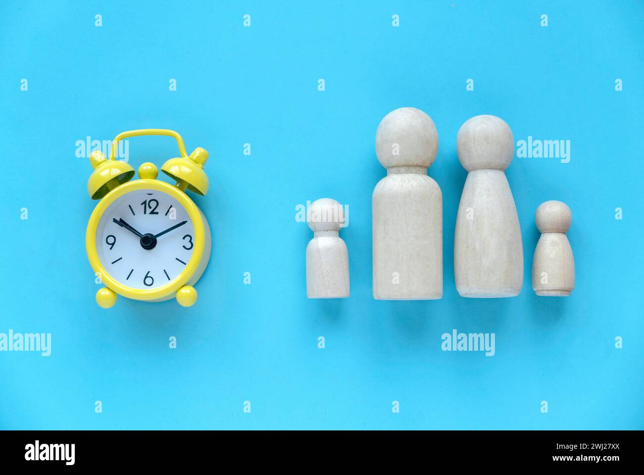 Tempo di qualità trascorso con la famiglia. Sveglia con persone in legno che rappresentano un genitore e un bambino. Foto Stock