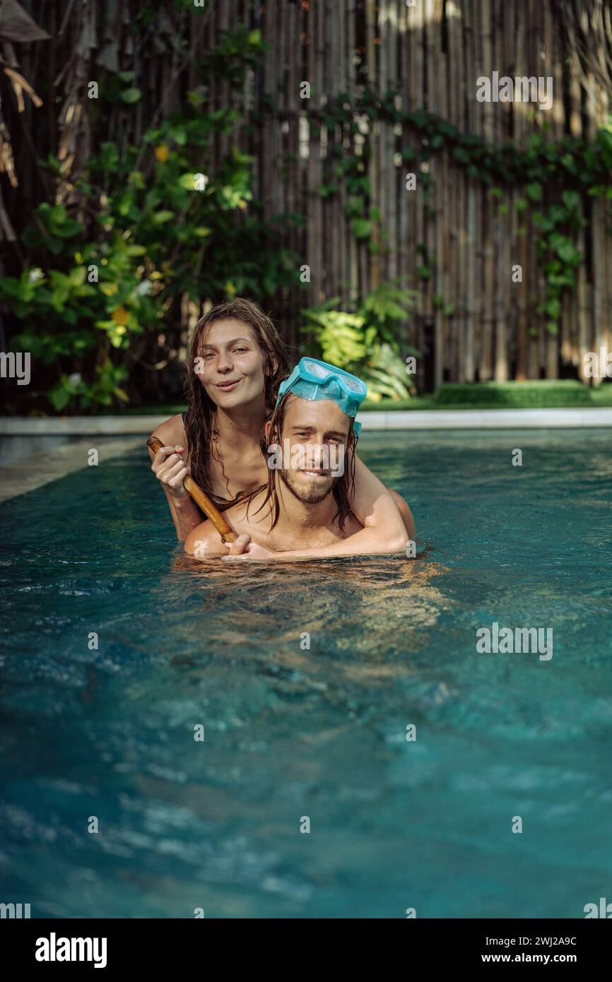 Felice giovane coppia innamorata in piscina in vacanza ai tropici. Foto Stock