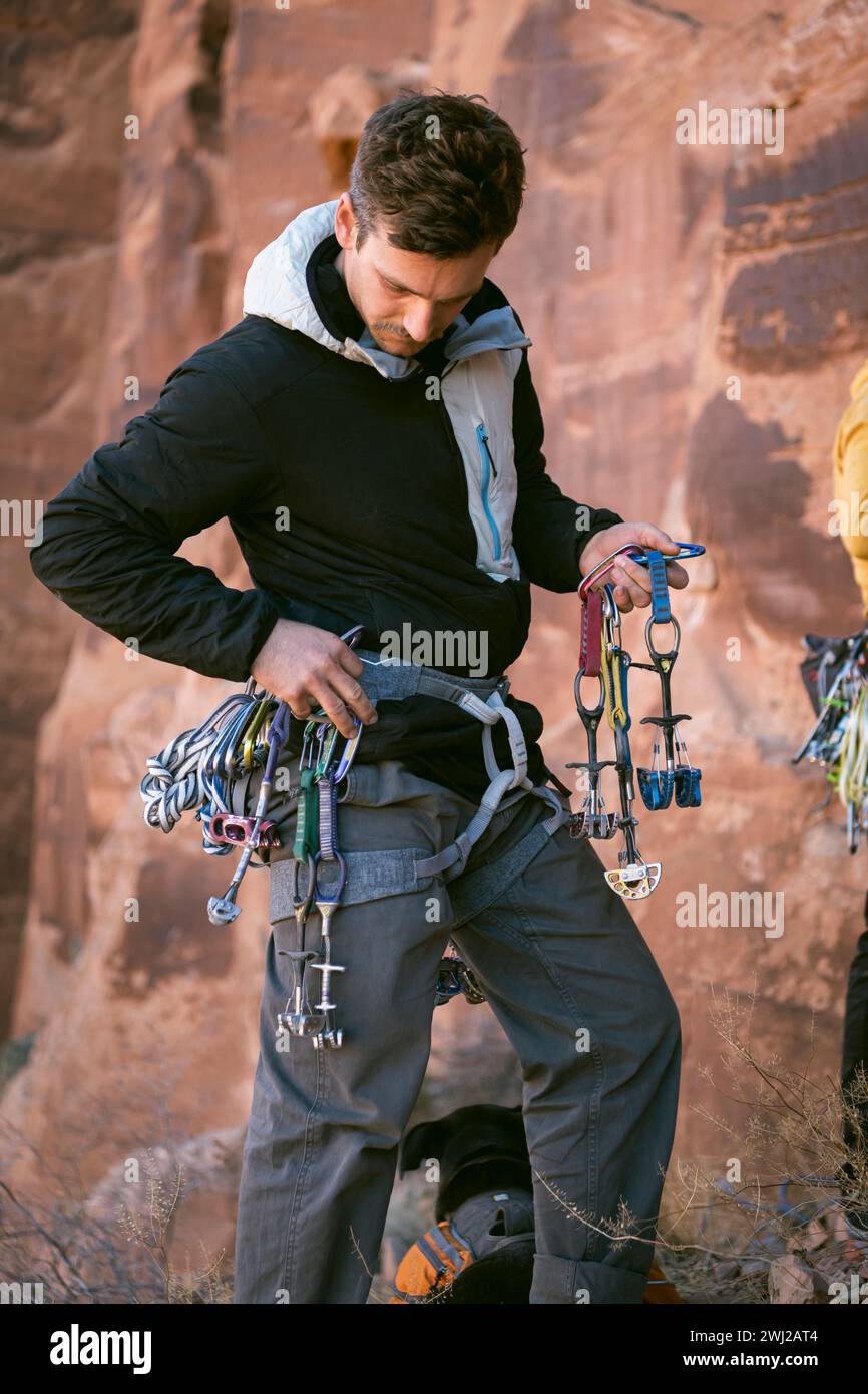 Alpinista maschile con equipaggiamento da arrampicata in piedi sulla scogliera nel deserto Foto Stock