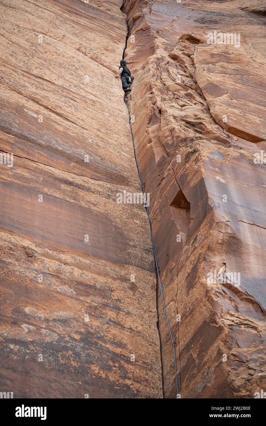 Maschio arrampicata su un'alta scogliera rocciosa Foto Stock